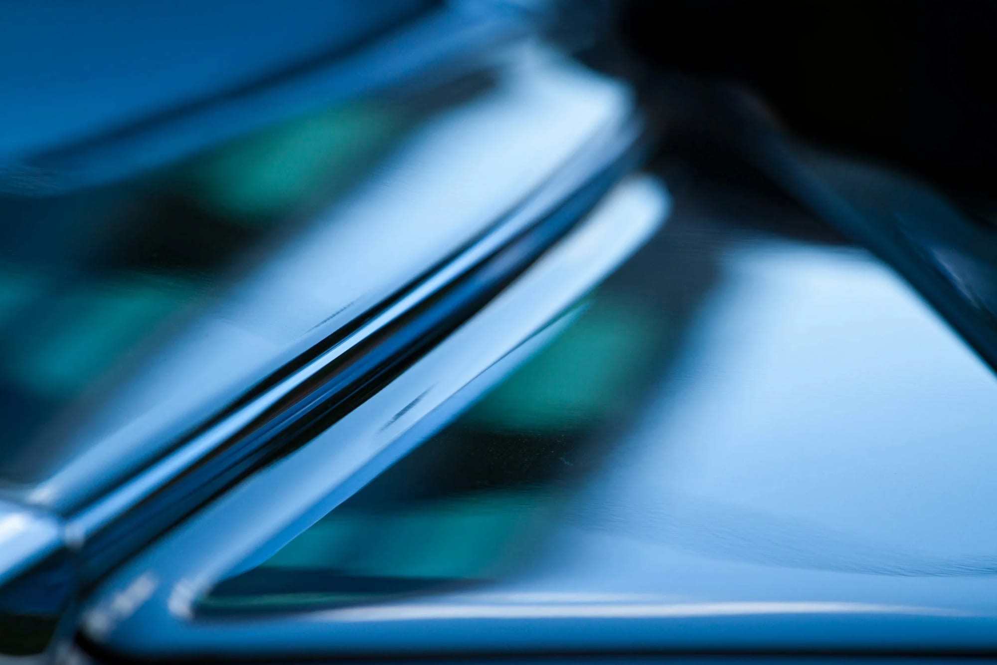Close-up of a metallic, reflective surface with overlapping layers and a blurred background.