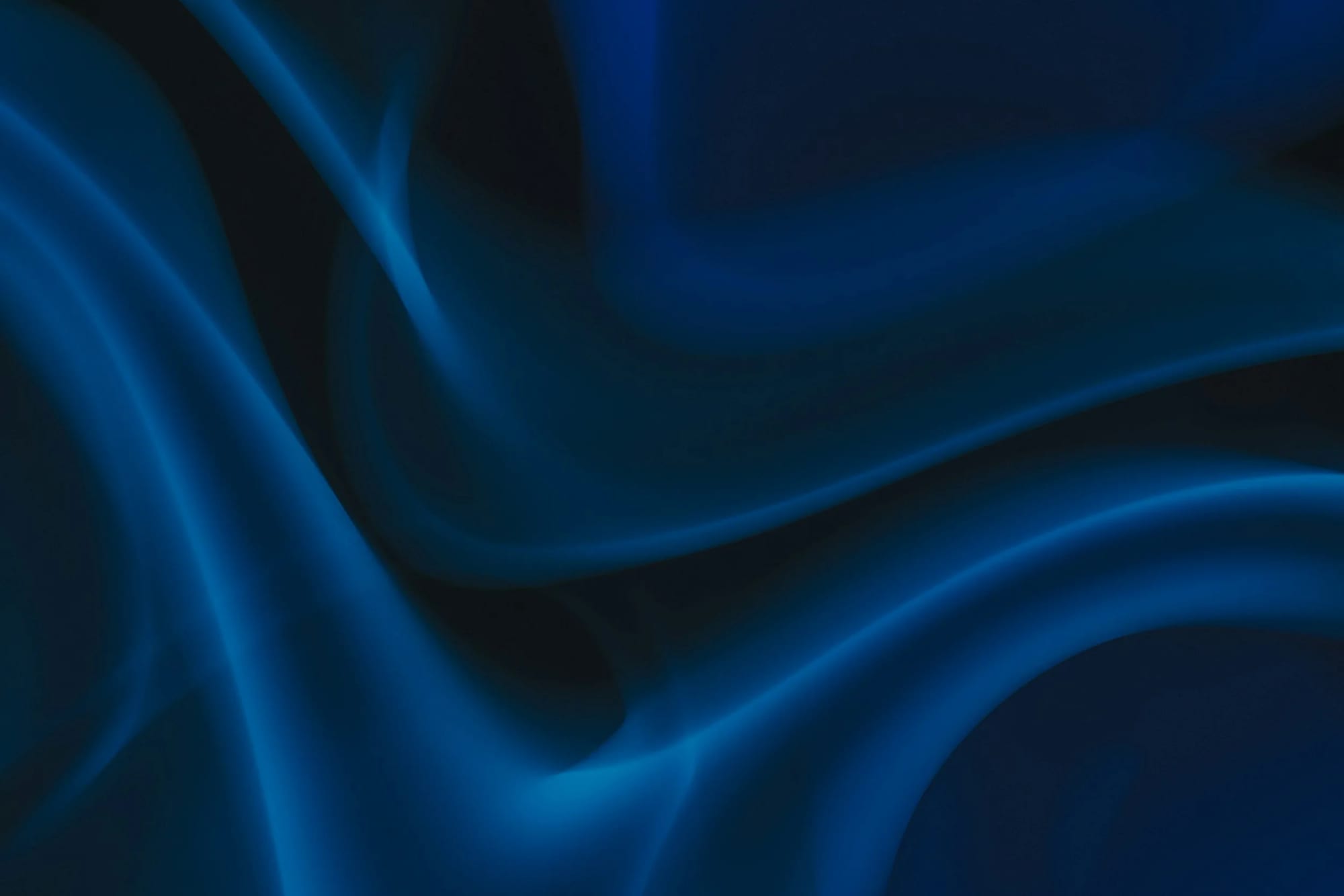 Abstract dark blue swirling shapes and curves.